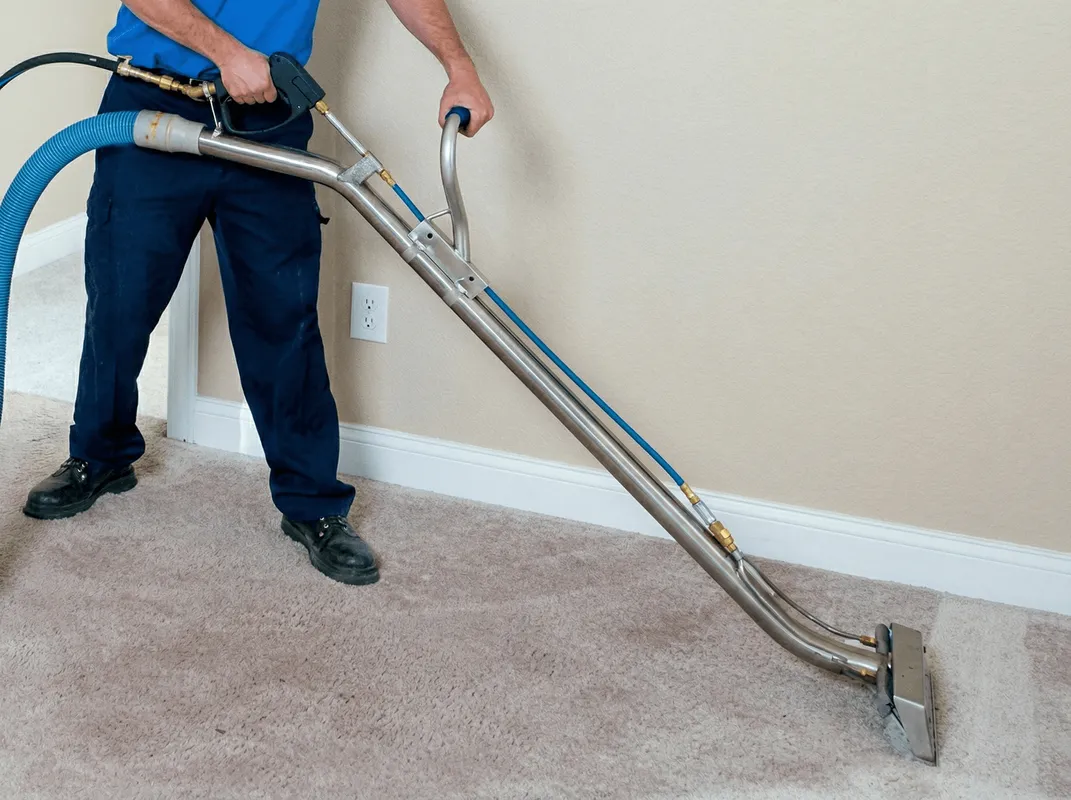 Professional operating a liquid removal machine on a carpeted floor in Providence, RI